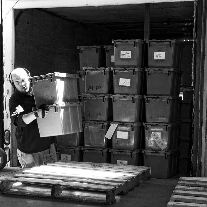 Man unloading bins from truck